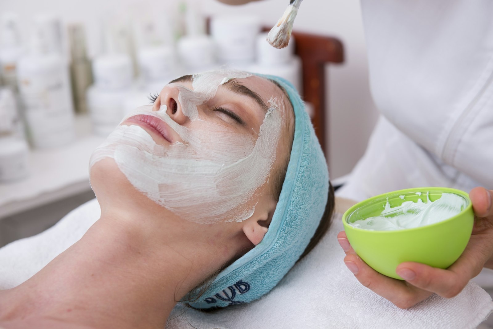 An aesthetician applying a treatment mask during a medical facial